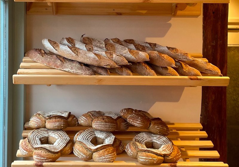 Houten rekken met baguettes en broodkransen