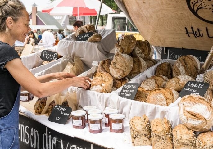Marktkraam vol brood van Het Lage Woud, met handgeschreven naambordjes